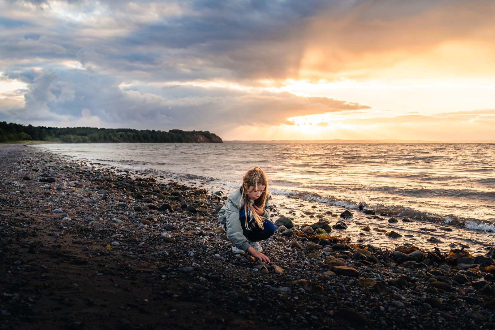 Pige på fossiljagt langs kysten