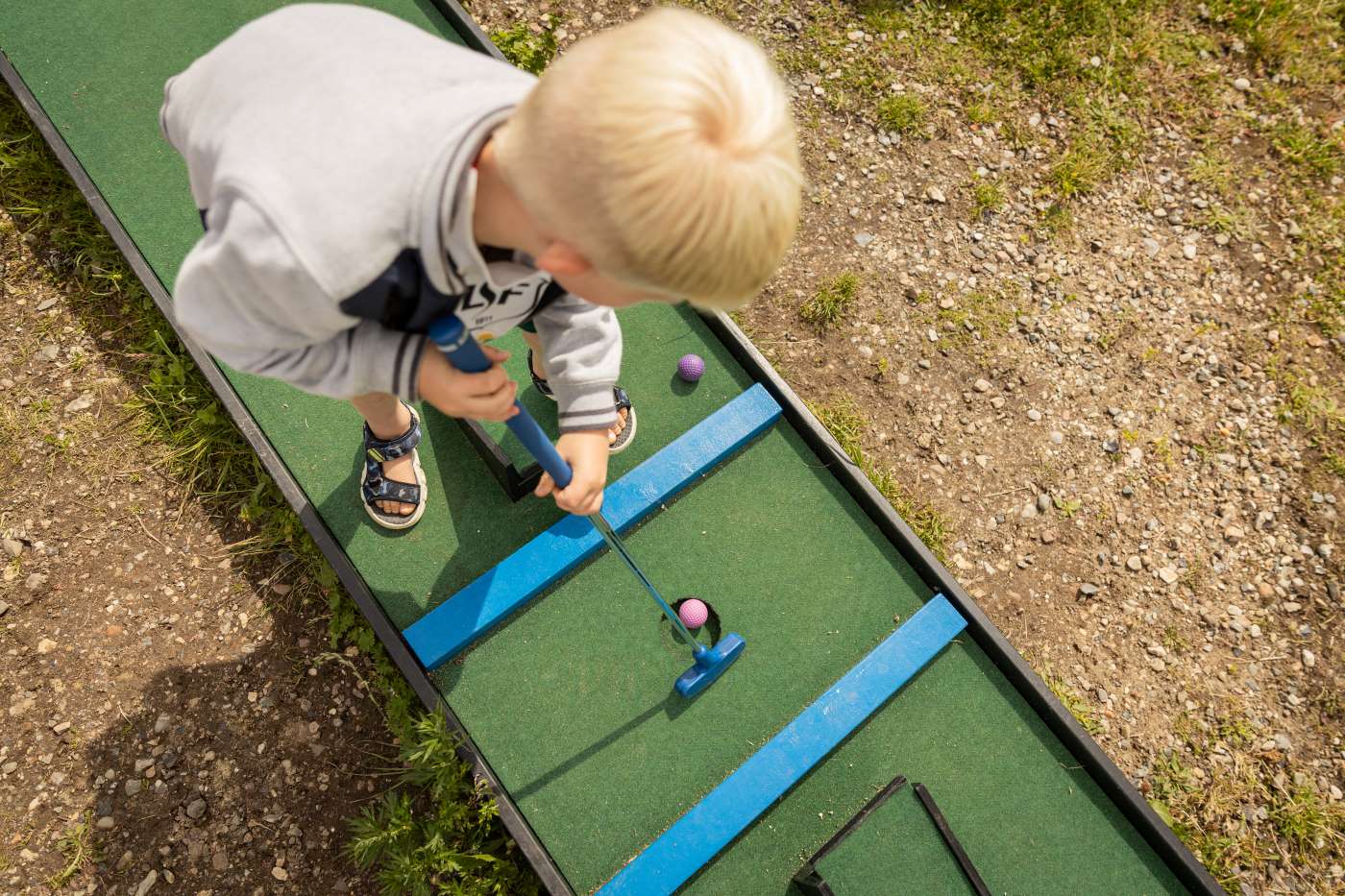 Dreng spiller minigolf i Havnens Oase