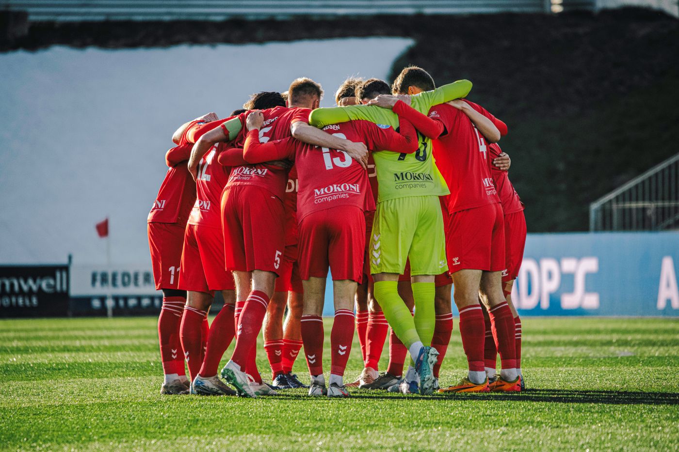 fodboldspillere står i klynge