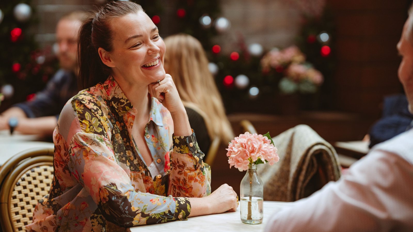 Par sidder ved bord på cafe